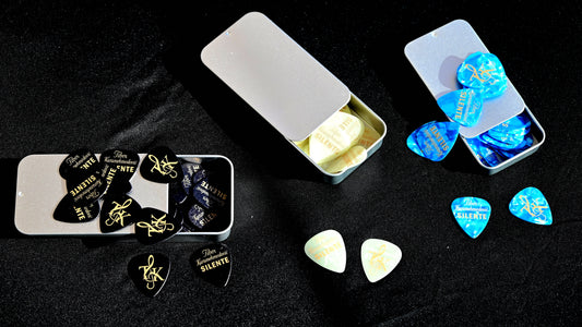 Guitar picks in various cases on a dark background