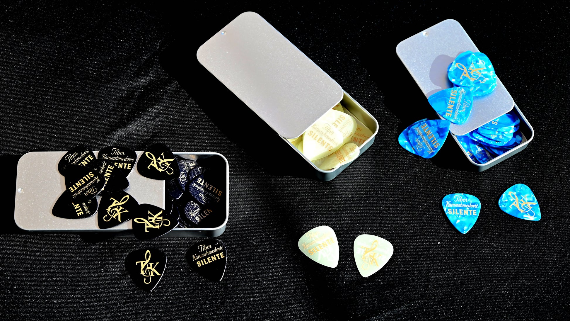 Guitar picks in various cases on a dark background