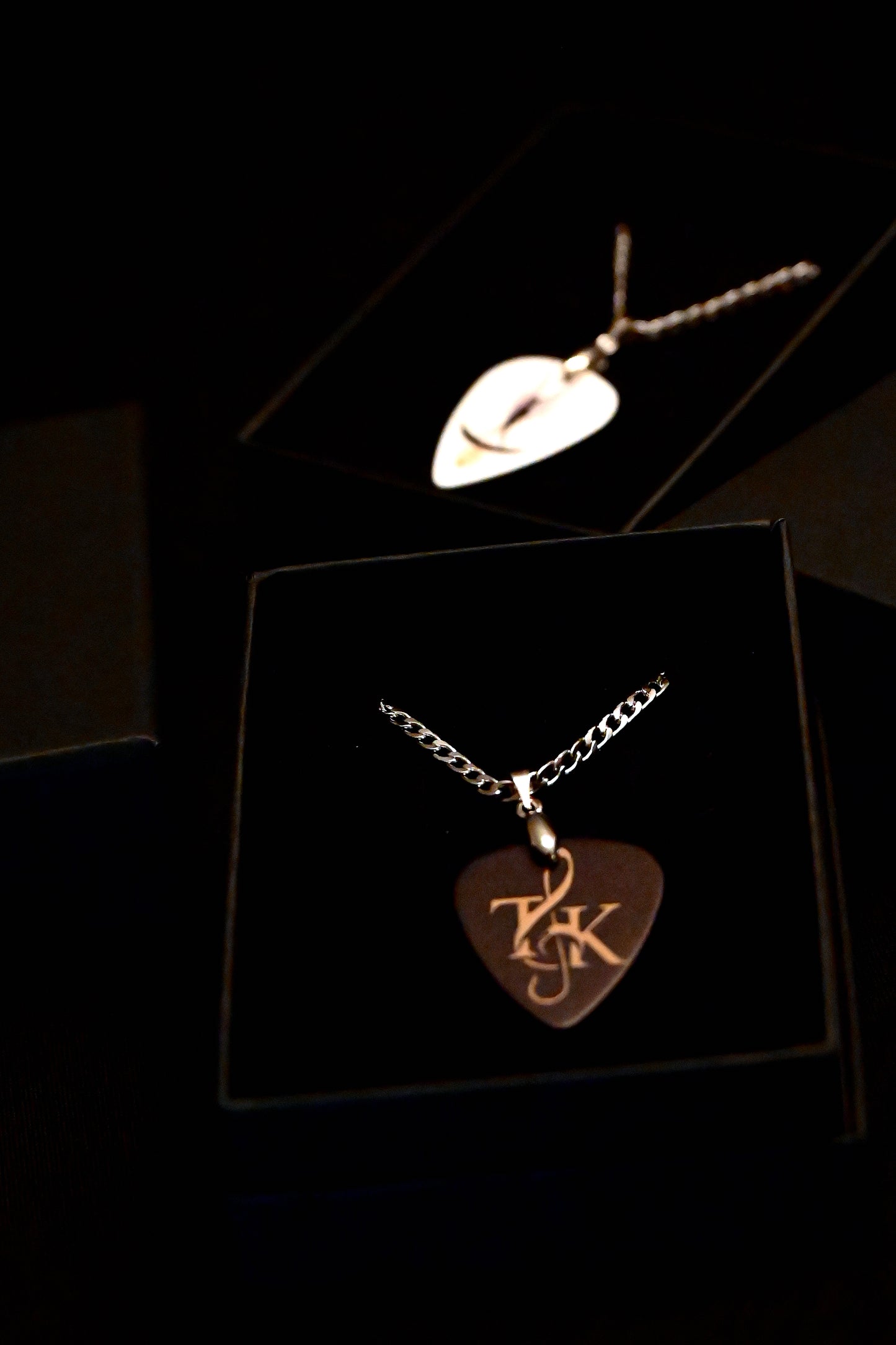 Gold necklace with a heart-shaped pendant on a dark background